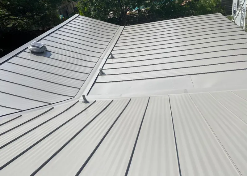 Solar attic fan installed on a metal roof for Roof Ventilation in Groves
